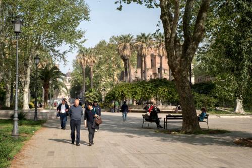 a group of people walking down a sidewalk in a park at STELLA GUEST HOUSE O AFFITTACAMERE in Rome