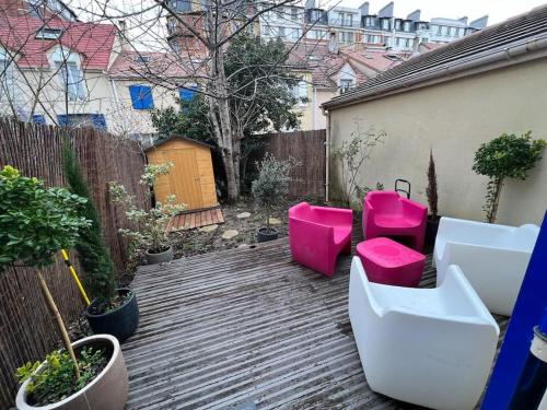 a backyard with pink toilets and a fence at Maison 8 voyageurs à 15mn des champs élysées in Asnières-sur-Seine