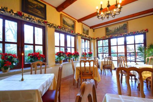 a dining room with tables and chairs and windows at Dom Polana Karpacz in Karpacz