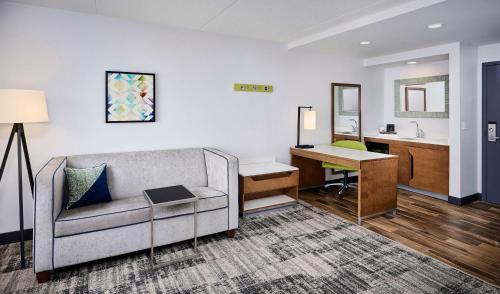 a living room with a couch and a desk at Hampton Inn & Suites by Hilton Windsor in Windsor