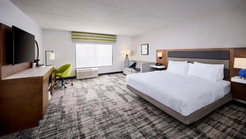 um quarto de hotel com uma cama, uma secretária e uma televisão em Hampton Inn & Suites by Hilton Windsor em Windsor