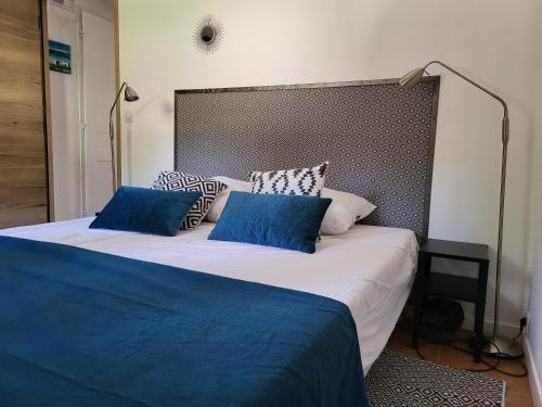 una camera da letto con un grande letto con cuscini blu di Les Trois Chênes a Les Angles Gard