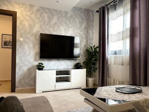 ein Wohnzimmer mit einem Flachbild-TV an der Wand in der Unterkunft La perle de maraval in Oran