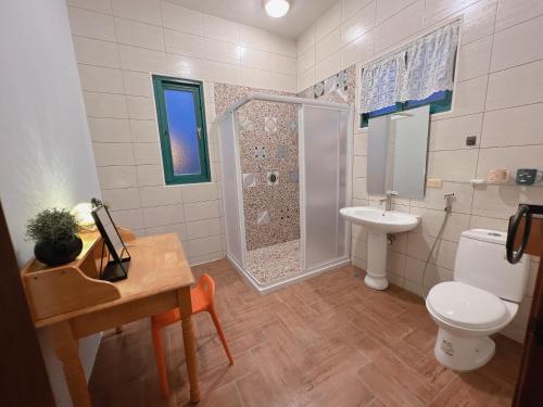 uma casa de banho com um chuveiro, um WC e um lavatório. em Azumaya guest house em Magong