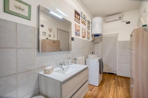 uma casa de banho com um lavatório e um frigorífico em Il Rifugio del Cuore em Collestatte