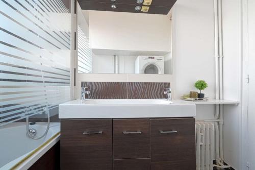 a bathroom with a sink and a microwave at Charmant Appartement au Cœur de Boulogne in Boulogne-Billancourt