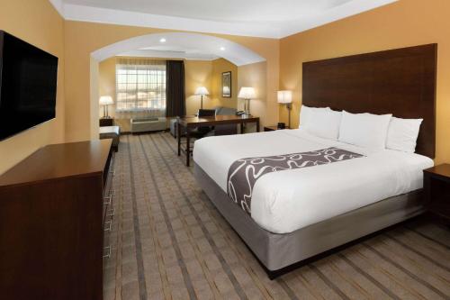 ein Hotelzimmer mit einem großen Bett und einem Schreibtisch in der Unterkunft La Quinta by Wyndham Houston NW Beltway8/WestRD in Houston