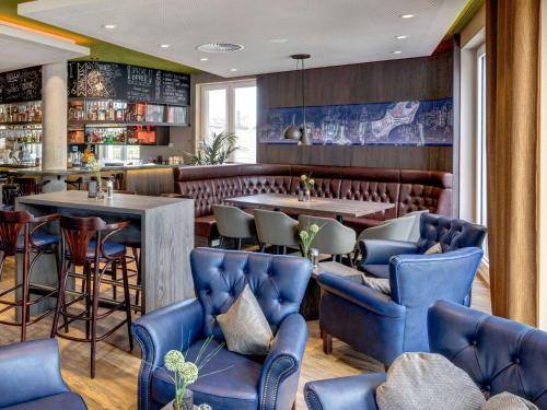 restauracja z niebieskimi krzesłami i stołami oraz bar w obiekcie ibis Styles Tuebingen w Tybindze