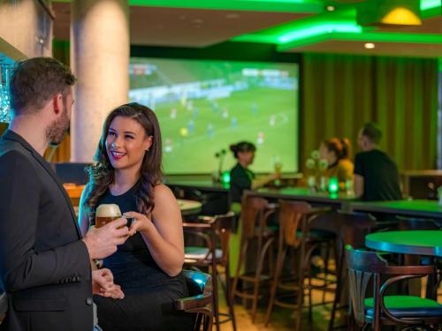 a man and a woman sitting in a bar talking at ibis Styles Tuebingen in Tübingen