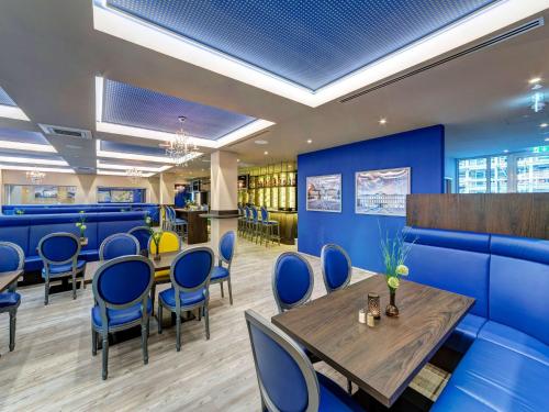 a restaurant with blue walls and a table and chairs at ibis Styles Rastatt Baden-Baden in Rastatt
