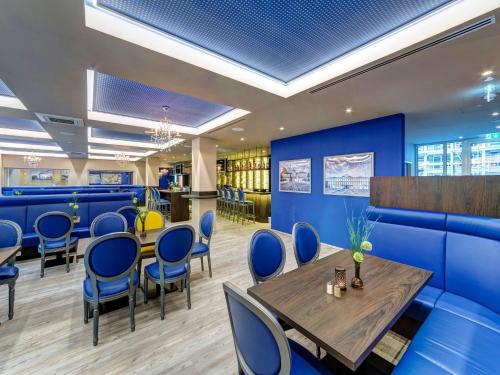 un restaurante con paredes azules, mesa y sillas en ibis Styles Rastatt Baden-Baden, en Rastatt