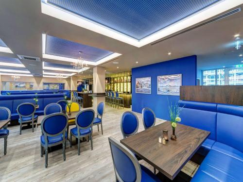 ein Restaurant mit blauen Wänden sowie einem Tisch und Stühlen in der Unterkunft ibis Styles Rastatt Baden-Baden in Rastatt
