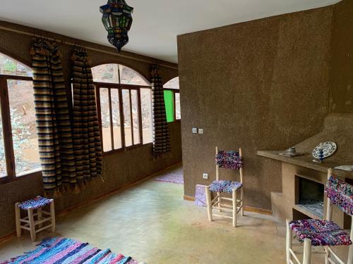 een woonkamer met 2 stoelen en een open haard bij Guest House Tigminou in Setti Fatma