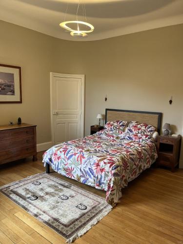 une chambre avec un grand lit et un tapis dans l'établissement Les Suites de L’Opéra, à Vichy