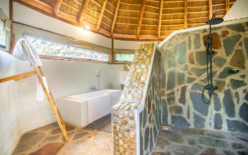 a bathroom with a staircase in a room with a giraffe wall at Embogo Safari Lodges in Katoke