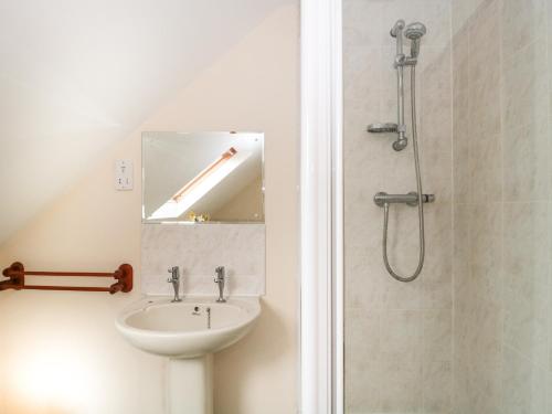 y baño con lavabo y ducha. en Cartshed Cottage, en Weymouth