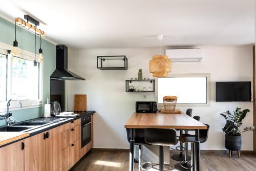 a kitchen with a wooden table and a counter top at Villa a la Possession in La Possession