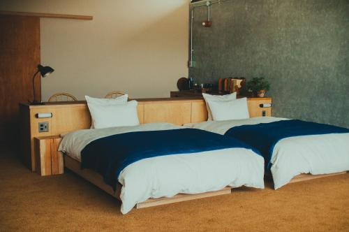 - 2 lits installés l'un à côté de l'autre dans une chambre dans l'établissement Hostel Saruya, à Fujiyoshida