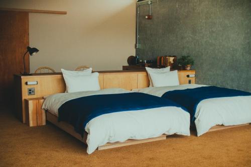 two beds sitting next to each other in a bedroom at Hostel Saruya in Fujiyoshida