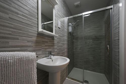 a bathroom with a sink and a glass shower at Jura Apartment in Oban