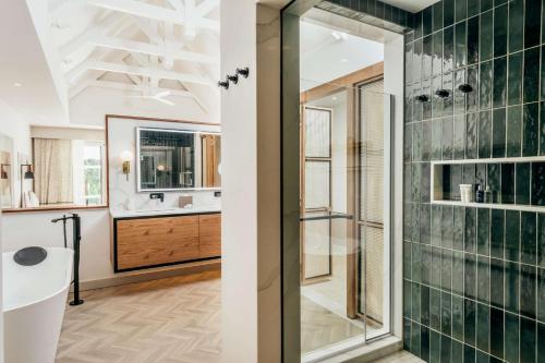 La salle de bains est pourvue d'une douche en verre et d'un lavabo. dans l'établissement Radisson Blu Azuri Resort & Spa, à Roches Noires