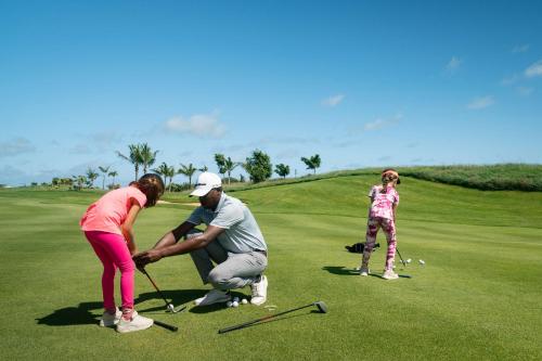 a couple of people playing golf on a golf course at Radisson Blu Azuri Resort & Spa in Roches Noires