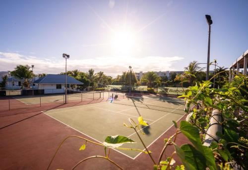 a tennis court with two tennis players on it at Radisson Blu Azuri Resort & Spa in Roches Noires