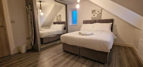 1 dormitorio con 1 cama grande y espejo en SAV Apartments Nottingham Road Loughborough - 2 Bed Apartment, en Loughborough