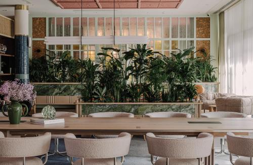 a dining room with a table and plants at PURO Hotel Poznań Stare Miasto in Poznań