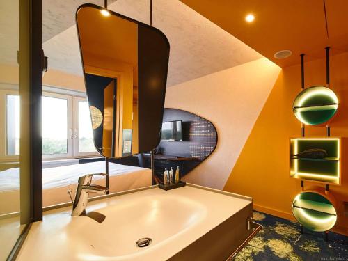 a bathroom with a sink and a mirror at ibis Styles Chelyabinsk in Chelyabinsk