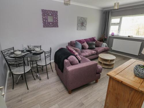 a living room with a purple couch and a table at Plas Nev in St. Davids