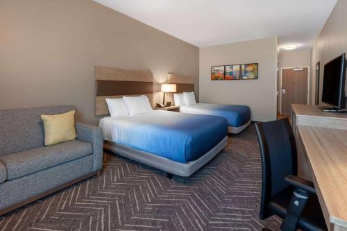 una camera d'albergo con due letti e un divano di La Quinta Inn & Suites by Wyndham Middletown a Middletown