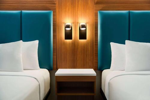 a room with two beds and a table between them at Wingate by Wyndham Williamsburg in Williamsburg