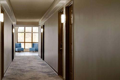 a hallway with two blue chairs and a window at Wingate by Wyndham Williamsburg in Williamsburg