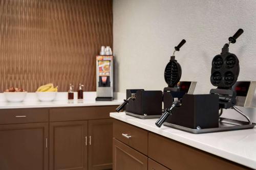 a kitchen with a counter with two machines on it at Wingate by Wyndham Williamsburg in Williamsburg