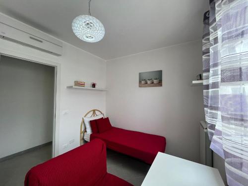 a living room with a red couch and a chair at Casa Rosaria in Lecce