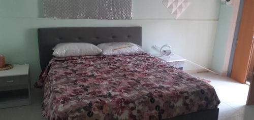 um quarto com uma cama com colcha floral em civico 53 em Rionero in Vulture