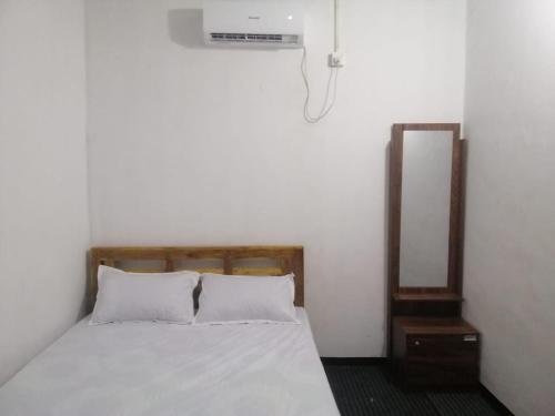 1 dormitorio con cama blanca y espejo en ZAHIRA Beach Place Kattankudy, en Kattankudi