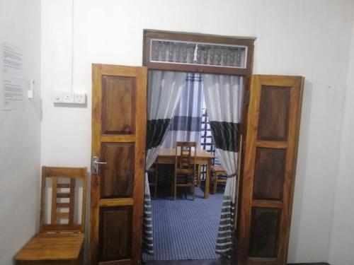 eine offene Tür zu einem Esszimmer mit einem Tisch in der Unterkunft ZAHIRA Beach Place Kattankudy in Kattankudi