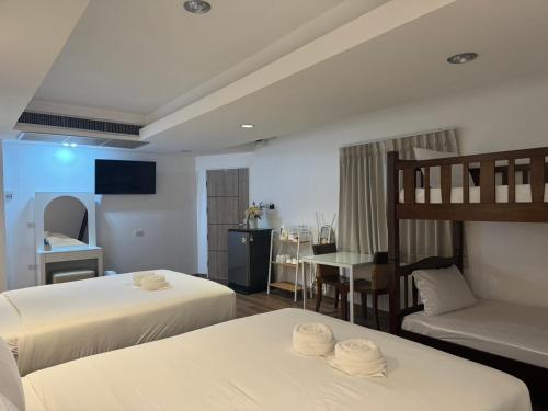 a hotel room with two beds and a couch at Neo Hatyai Hotel in Hat Yai