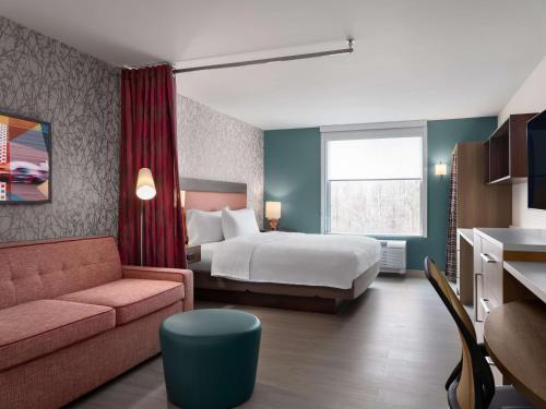pokój hotelowy z łóżkiem i kanapą w obiekcie Home2 Suites By Hilton Brownsburg w mieście Brownsburg