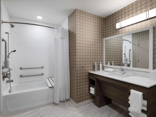 een badkamer met een bad, een wastafel en een douche bij Home2 Suites By Hilton Brownsburg in Brownsburg