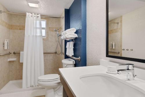 Łazienka z białą toaletą i umywalką w obiekcie Spark by Hilton Ormond Beach Oceanfront w mieście Ormond Beach