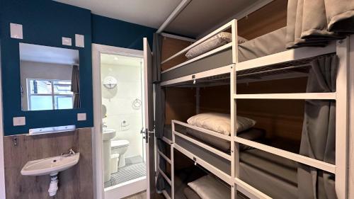 Zimmer mit Etagenbetten, Waschbecken und Bad in der Unterkunft Smart Camden Inn Hostel in London