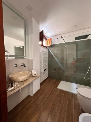 a bathroom with a sink and a glass shower at Luxury Studio Suite in Niscemi