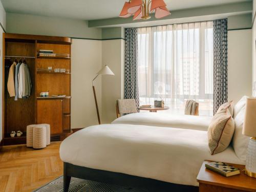 a bedroom with a large bed and a large window at The Hoxton Vienna in Vienna