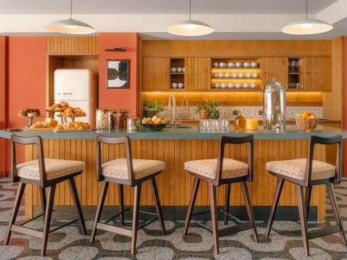 a kitchen with a breakfast bar with two stools at The Hoxton Vienna in Vienna