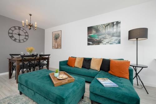 ein Wohnzimmer mit einem grünen Sofa und einem Tisch in der Unterkunft Schillera Apartments Warsaw by Renters in Warschau