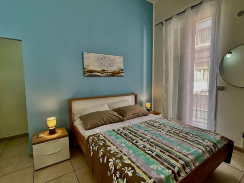 een slaapkamer met een bed en een blauwe muur bij Casa Felice in Siracusa