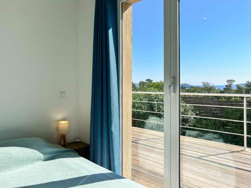 a bedroom with a bed and a sliding glass door at Royal Palm in Porto-Vecchio